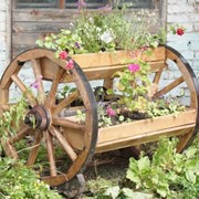 Цветник на деревянных колесах фото