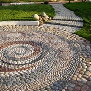 Создание мозаичных рисунков из гальки в саду фотография