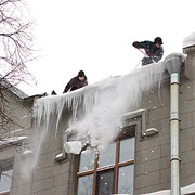 Уборка снега наледи промышленными альпинистами фотография