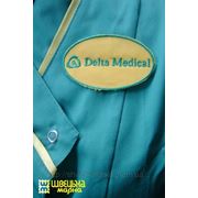 Вышивка логотип на медицинском костюме фотография