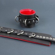 Поддвернутые чёрные наручники с застежкой-ремешком и красной изнанкой фото