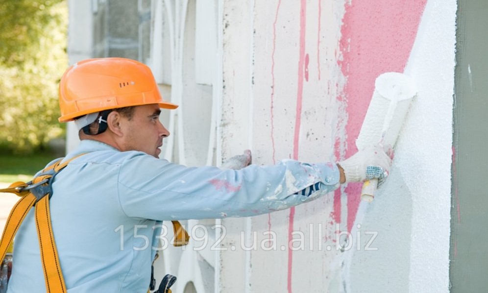 Маляр. Моляр. Ремонт в квартире. Окрашенные фасады зданий. Рабочий красит стену.