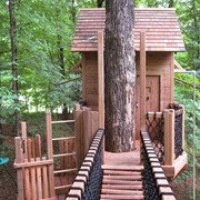 Дом на дереве с веревочной переправой фотография