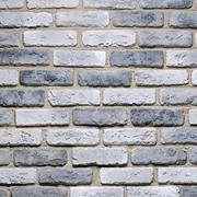 Кирпич Шишка серый на белом цементе фотография