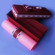 Розовый свиток в красной дизайнерской упаковке фото
